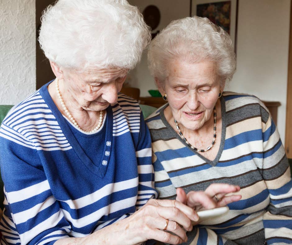 2 senior citizen women looking at mobile phone